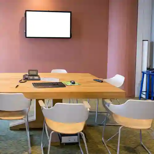 Bild på mindre konferensrum med bord och stolar.