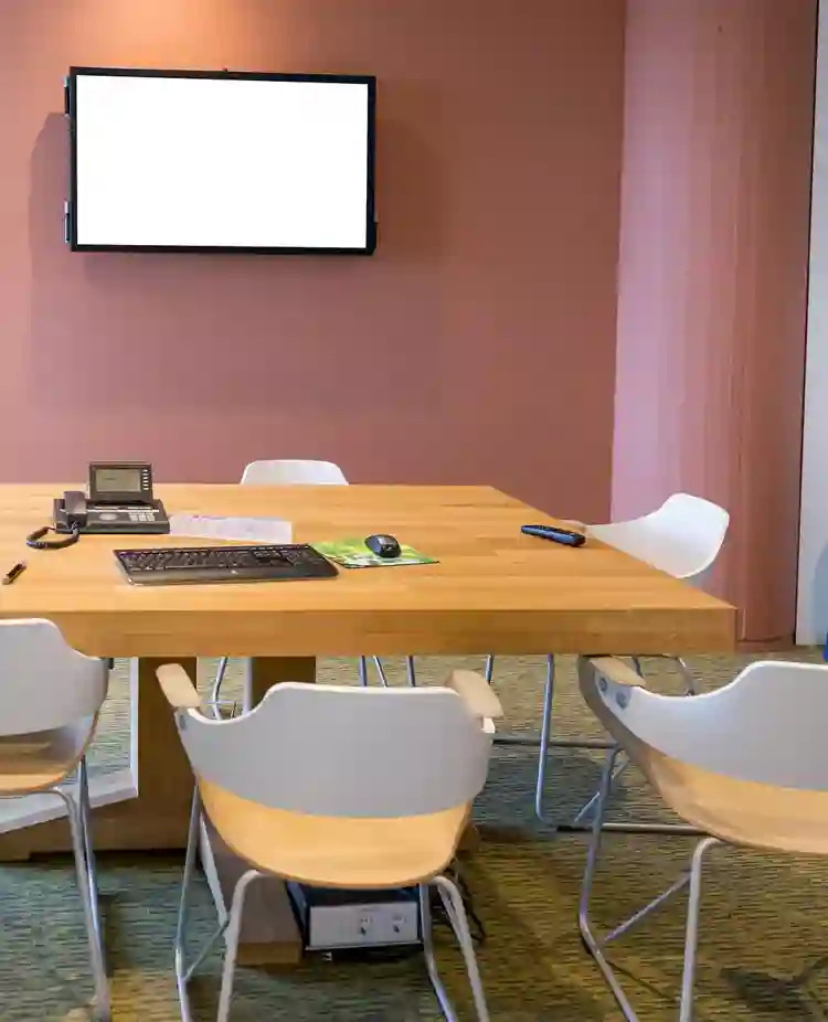 Bild på mindre konferensrum med bord och stolar.