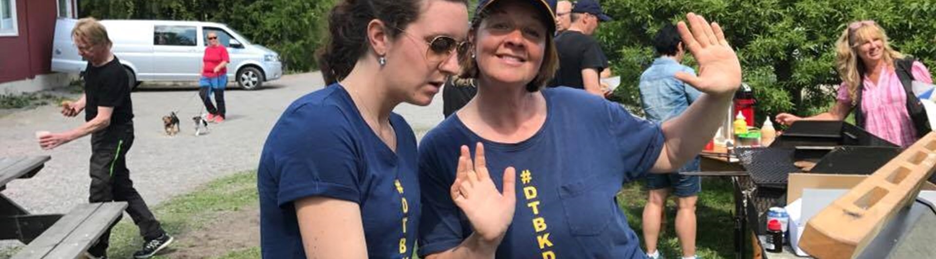 Glada grillare i blå t-shirts med tryck #dtbkdogs jobbar som funktionärer på DTBK.
