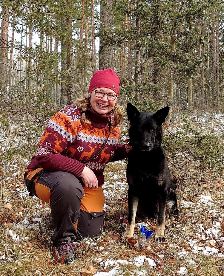 Matte och hund som sitter i skogen
