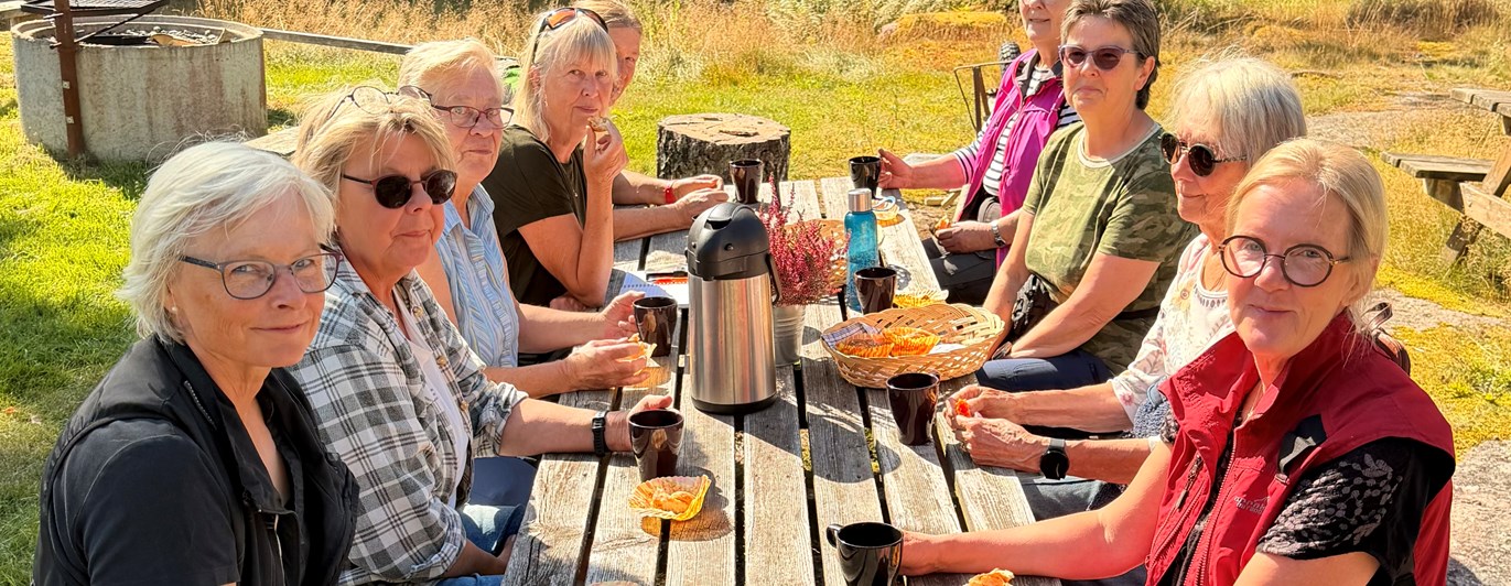 En grupp människor sitter och fikar