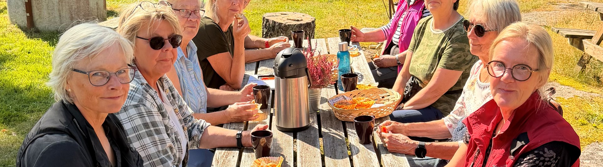 En grupp människor sitter och fikar