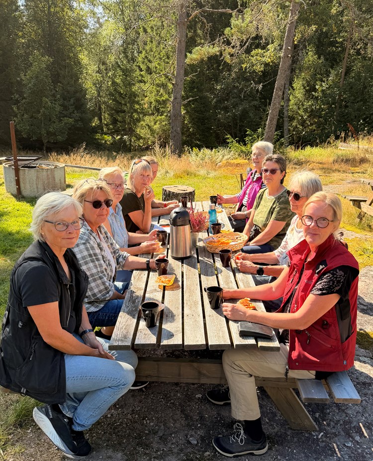 En grupp människor sitter och fikar