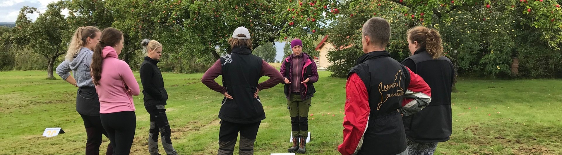 Instruktör som håller teorigenomgång med kursdeltagare utomhus