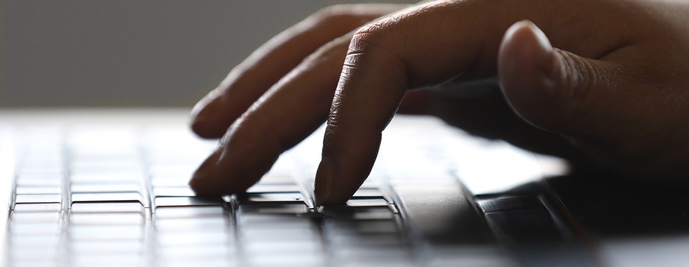Bild på skrivande hand på tangentbord.