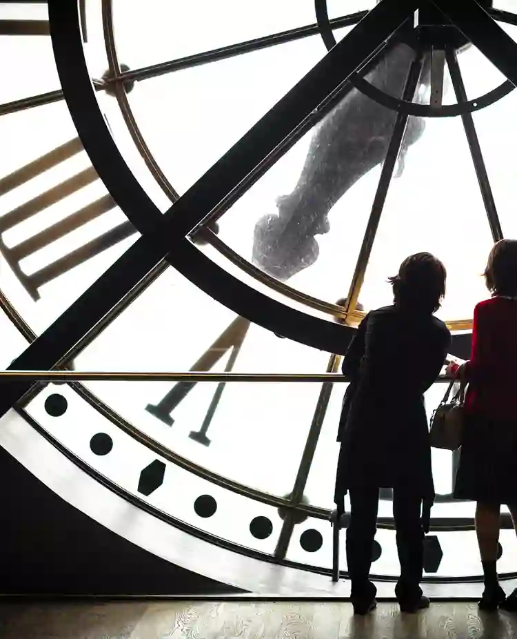 Bild som visar två kvinnosiluetter som står inuti en stor klocka.