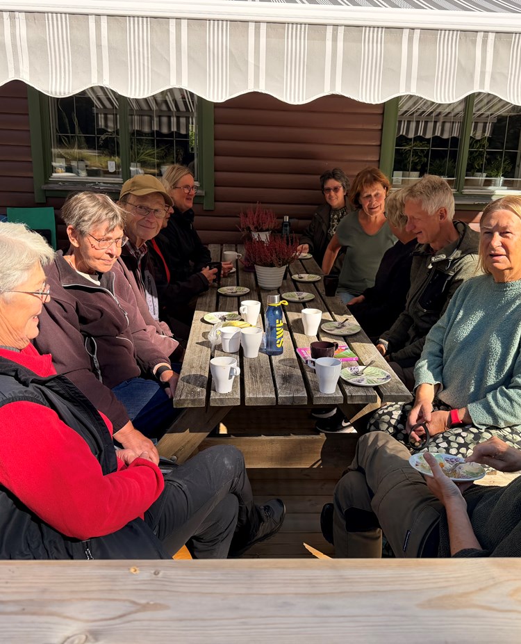 En grupp människor sitter och fikar