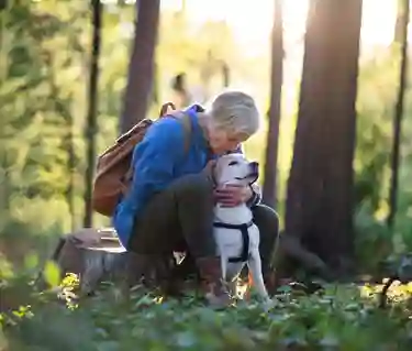 Kvinna med hund i skogen
