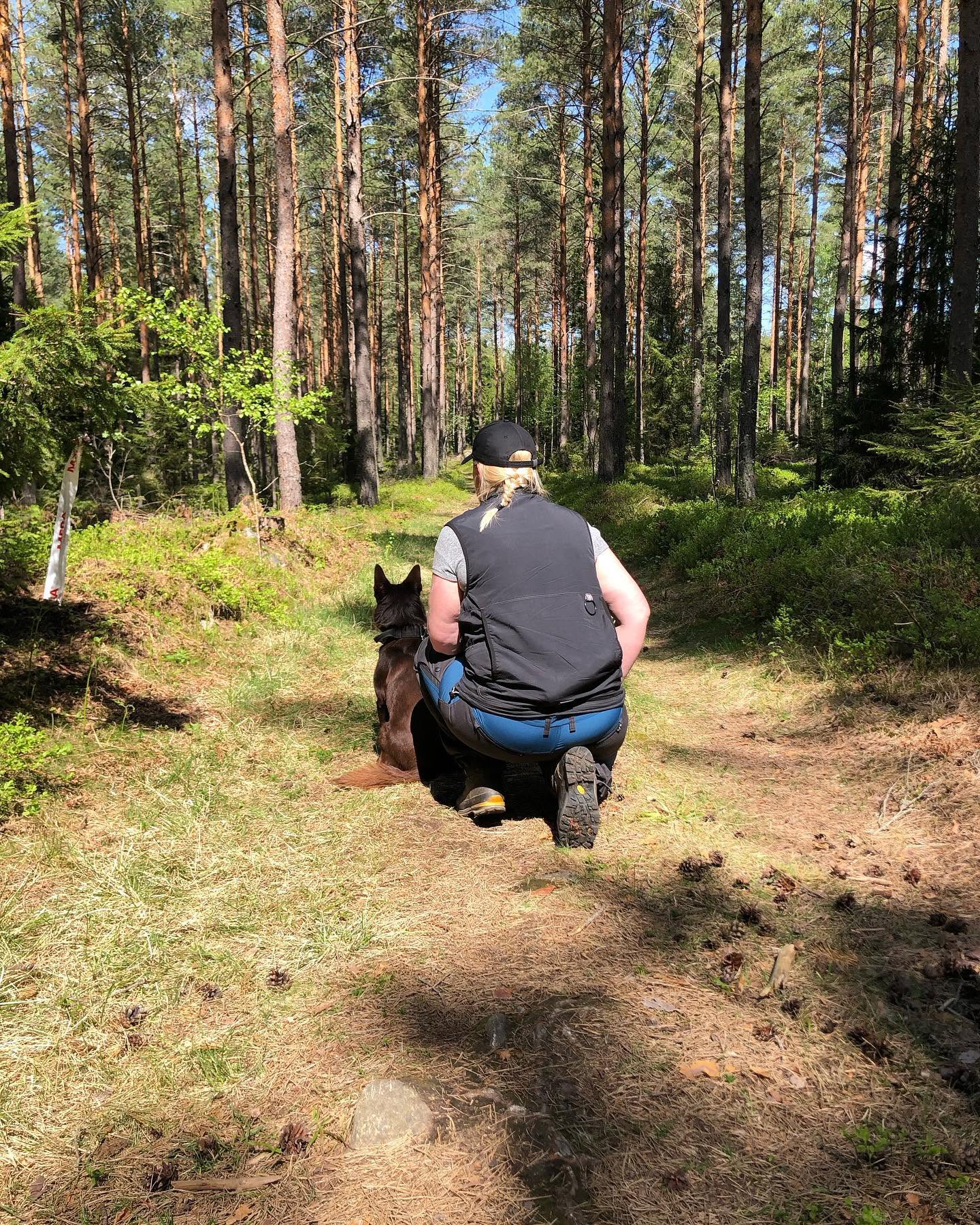 Sittande förare med hund framför