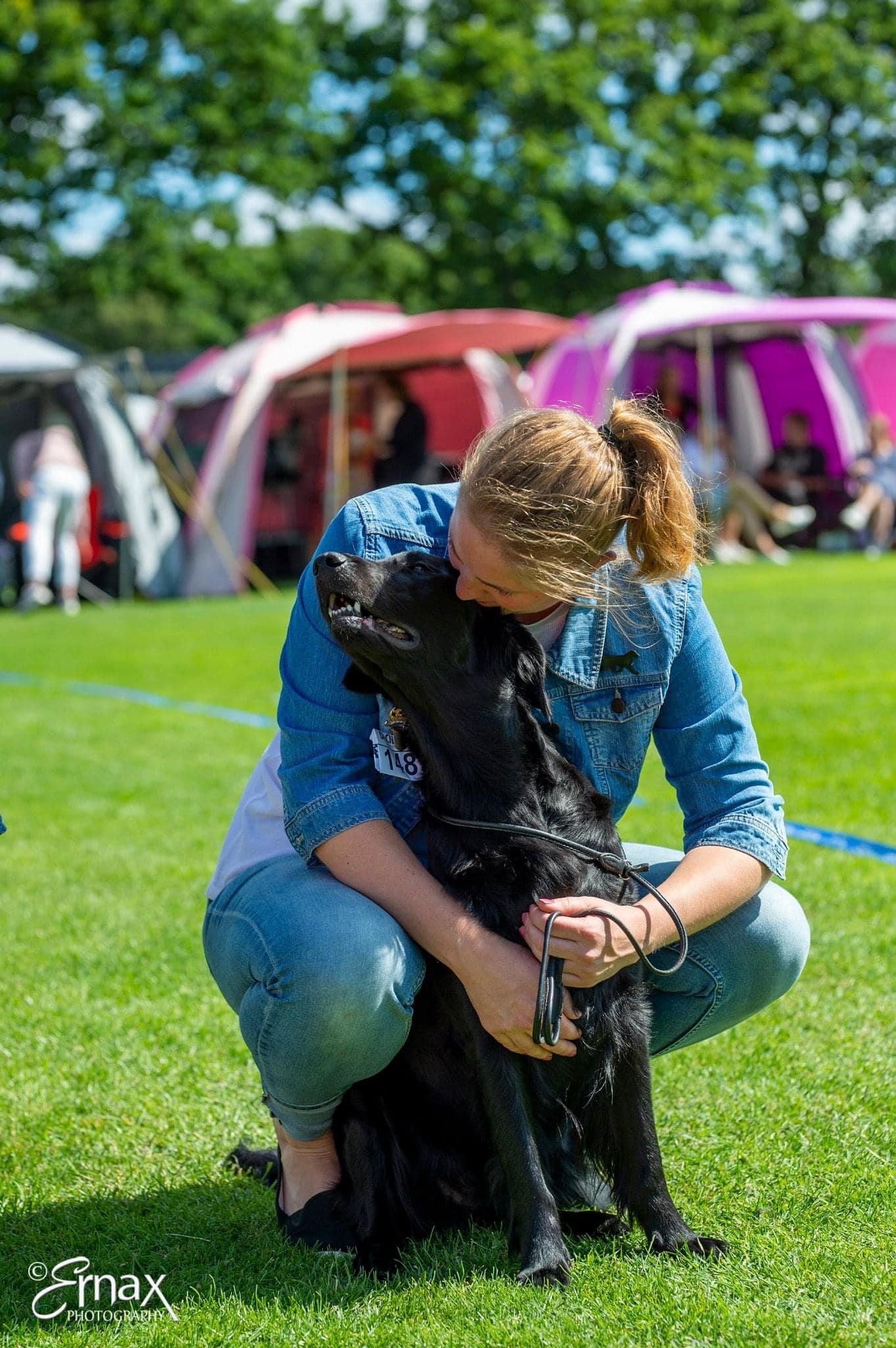 En bild på ett ekipage där föraren kramar om sin svarta hund