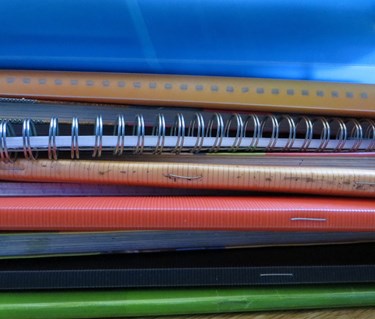 Bild som visar en hög med anteckningsböcker.