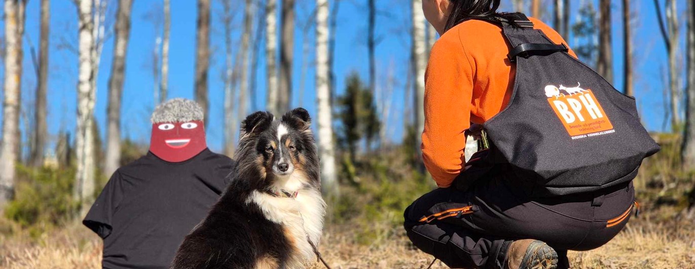 En testledare som sitter på huk med en BPH väst på sig.