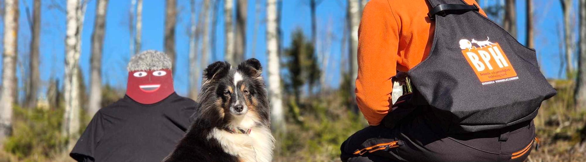 En testledare som sitter på huk med en BPH väst på sig.