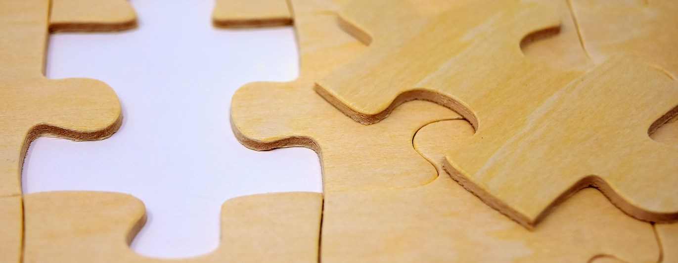 Bild på ett puzzel som endast saknar en puzzelbit.