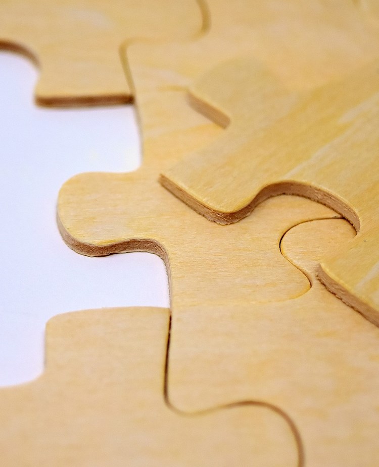 Bild på ett puzzel som endast saknar en puzzelbit.