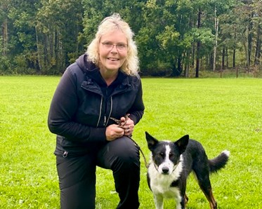 Bordercollie poserar tillsammans med förare