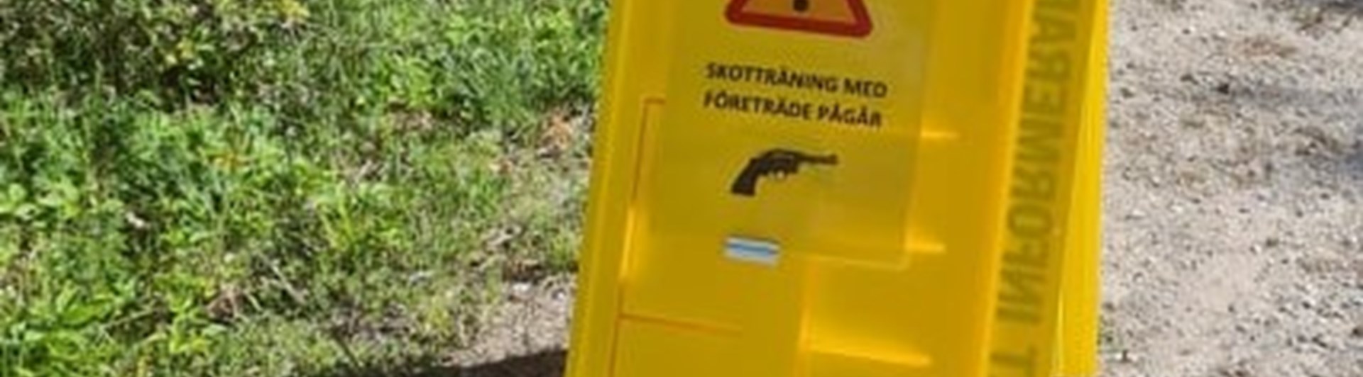 Skyltställ på parkeringen med info om skotträning