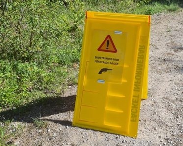 Skyltställ på parkeringen med info om skotträning