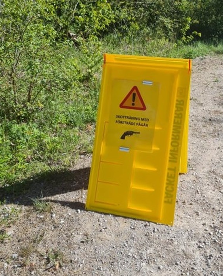 Skyltställ på parkeringen med info om skotträning