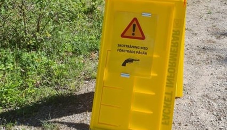 Skyltställ på parkeringen med info om skotträning