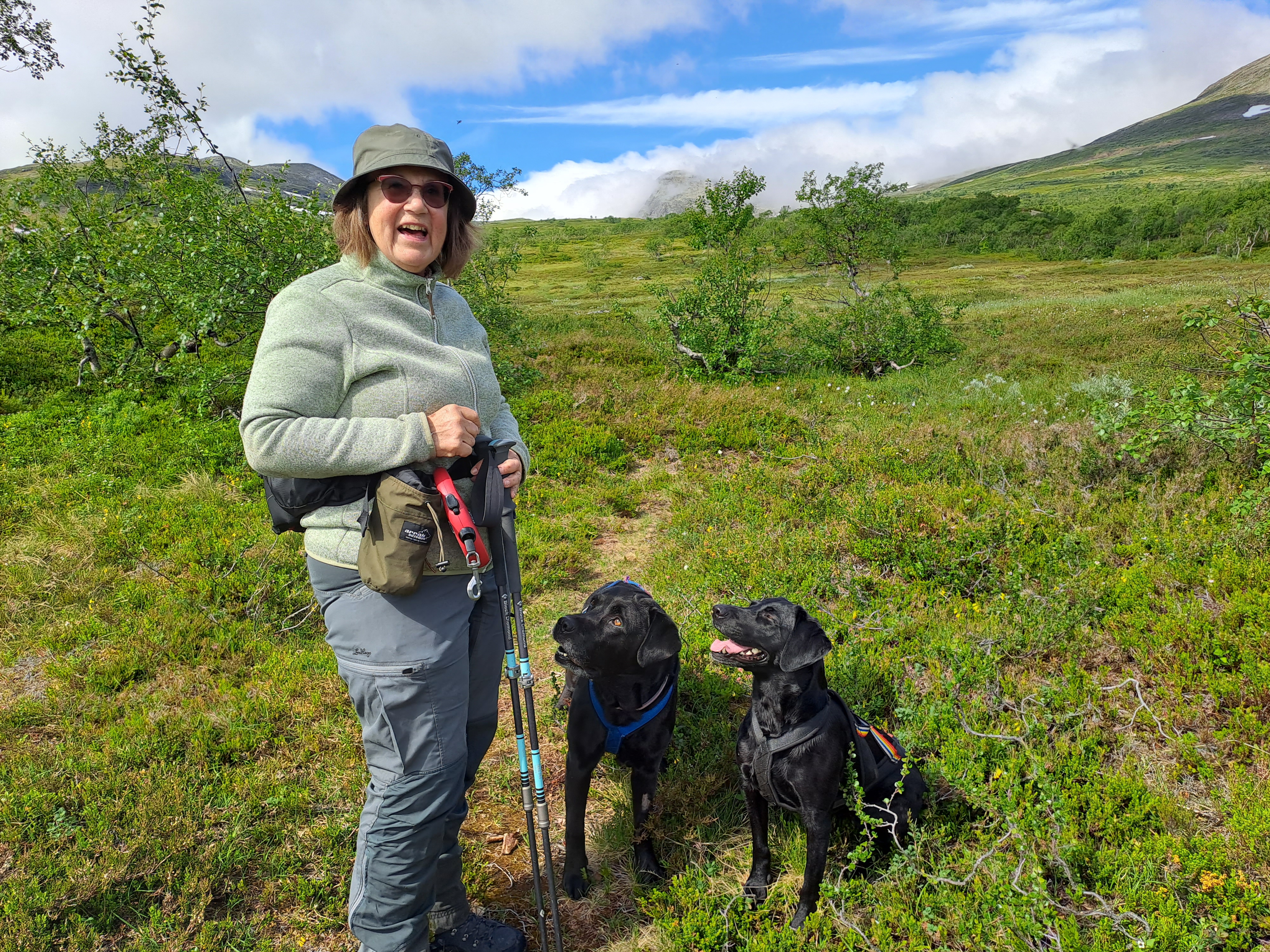 Anna-Karin på fjället med sina två labradorer. Sommar och soligt.