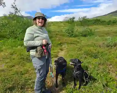 Anna-Karin på fjället med sina två labradorer. Sommar och soligt.
