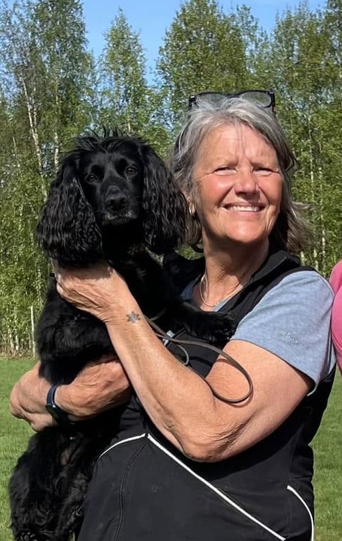 Lena håller upp sin hund Geni, profilbild