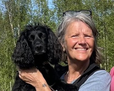 Lena håller upp sin hund Geni, profilbild