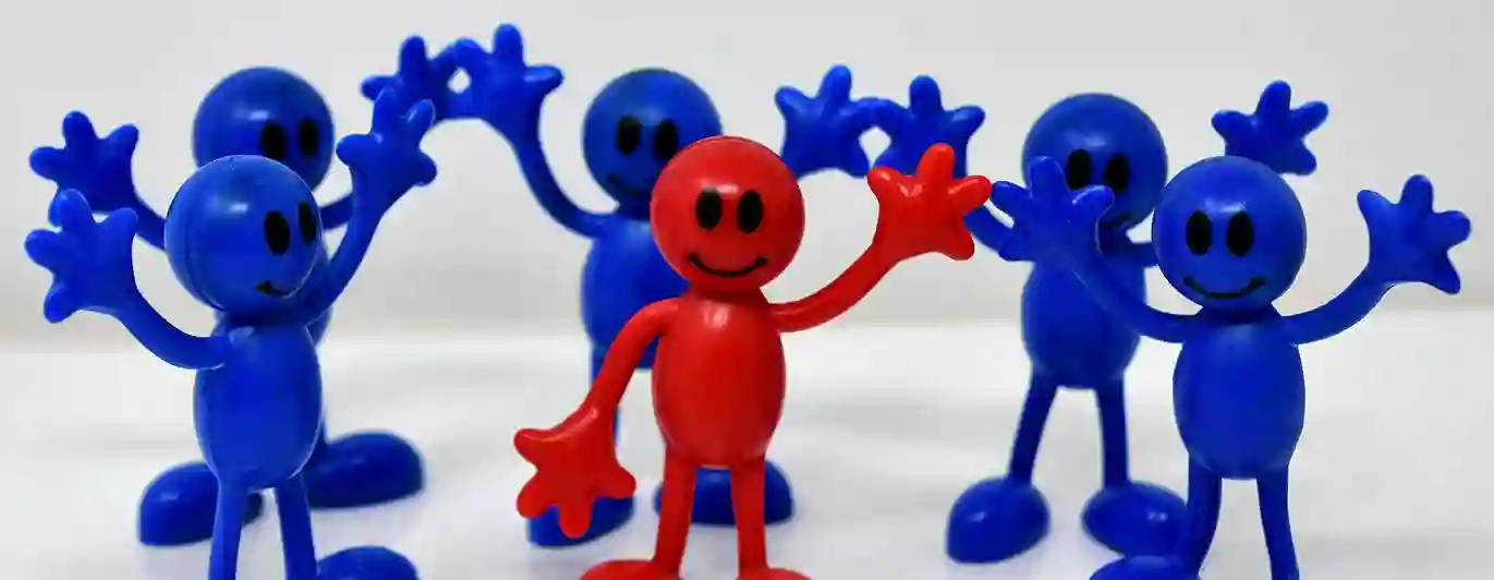 Fem blå figurer och en röd figur med händerna uppe i luften
