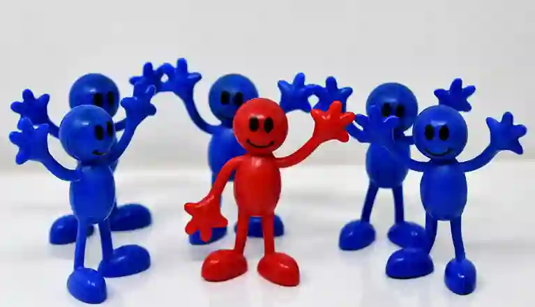 Fem blå figurer och en röd figur med händerna uppe i luften