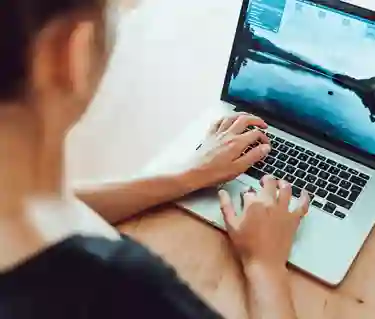 Person som sitter och skriver på dator. 