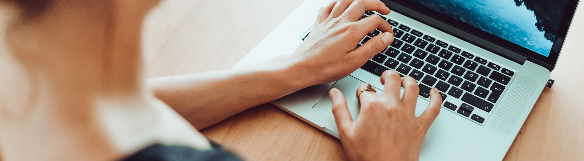 Person som sitter och skriver på dator.